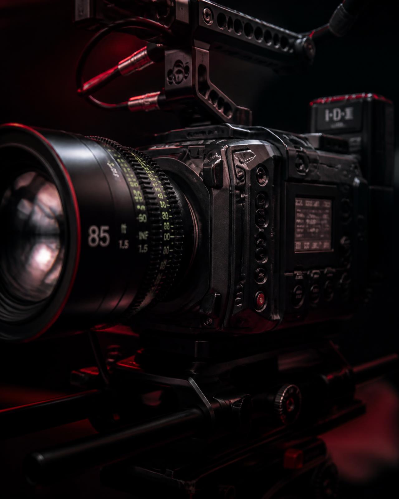 Professional cinema camera lit with deep red light in a dark studio